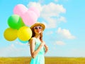 Portrait happy young smiling woman with an air colorful balloons is enjoying a summer day on meadow blue sky Royalty Free Stock Photo