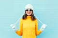 Portrait happy young smiling woman wearing a sunglasses, knitted hat, sweater over blue Royalty Free Stock Photo