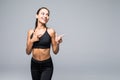 Portrait of a happy young sports girl pointing two fingers at copy space isolated over gray background Royalty Free Stock Photo