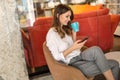 Portrait of a happy young success woman using smartphone and drinking coffee in break Royalty Free Stock Photo