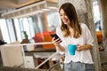 Portrait of a happy young success woman using smartphone and drinking coffee in break Royalty Free Stock Photo