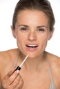 Portrait of happy young woman applying lip gloss Royalty Free Stock Photo