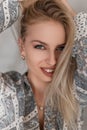 Portrait of a happy young woman with a beautiful smile with blue eyes with sexy lips with blond hair in a fashionable shirt Royalty Free Stock Photo