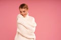 Portrait of happy young woman with blonde short hair wearing warm wool sweater, smiling. A lot of copy space on pink pastel studio Royalty Free Stock Photo