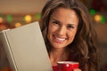 Portrait of happy young woman with book cup of hot chocolate Royalty Free Stock Photo