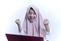 Portrait of happy young woman celebrating success with arms up and shout out in front of laptop Royalty Free Stock Photo