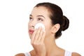 Portrait of happy young woman cleaning skin by cotton pad