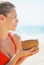 Portrait of happy young woman drinking coconut milk on beach Royalty Free Stock Photo