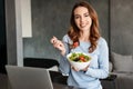 Portrait of a happy young woman eating fresh salad Royalty Free Stock Photo