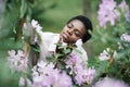 Blossom Flowers. Portrait of happy young woman with purple flower on tree in the park Royalty Free Stock Photo