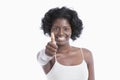 Portrait of a happy young woman gesturing thumbs up over white background Royalty Free Stock Photo