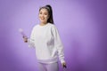 Portrait of happy young woman going on vacation with passport and her suitcase over a violet background Royalty Free Stock Photo