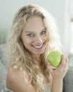 Portrait of happy young woman holding apple in house Royalty Free Stock Photo