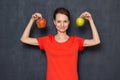 Portrait of happy young woman holding apples in hands near head Royalty Free Stock Photo