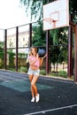 Portrait happy young woman holding basketball on outdoor court Royalty Free Stock Photo