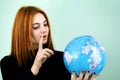 Portrait of a happy young woman holding geographic globe of the world in her hands. Travel destination and planet protection Royalty Free Stock Photo