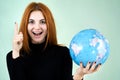 Portrait of a happy young woman holding geographic globe of the world in her hands. Travel destination and planet protection Royalty Free Stock Photo