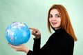 Portrait of a happy young woman holding geographic globe of the world in her hands. Travel destination and planet protection Royalty Free Stock Photo