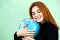 Portrait of a happy young woman holding geographic globe of the world in her hands. Travel destination and planet protection