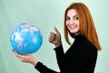 Portrait of a happy young woman holding geographic globe of the world in her hands. Travel destination and planet protection Royalty Free Stock Photo