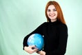 Portrait of a happy young woman holding geographic globe of the world in her hands. Travel destination and planet protection Royalty Free Stock Photo