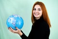 Portrait of a happy young woman holding geographic globe of the world in her hands. Travel destination and planet protection Royalty Free Stock Photo