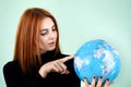 Portrait of a happy young woman holding geographic globe of the world in her hands. Travel destination and planet protection Royalty Free Stock Photo