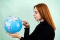 Portrait of a happy young woman holding geographic globe of the world in her hands. Travel destination and planet protection