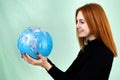 Portrait of a happy young woman holding geographic globe of the world in her hands. Travel destination and planet protection Royalty Free Stock Photo