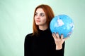 Portrait of a happy young woman holding geographic globe of the world in her hands. Travel destination and planet protection