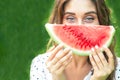 Portrait of happy young woman is holding slice of watermelon over green background Royalty Free Stock Photo