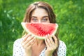 Portrait of happy young woman is holding slice of watermelon over green background Royalty Free Stock Photo