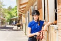 Jockey girl standing by riding stables with reins Royalty Free Stock Photo