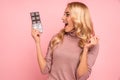 Portrait of a happy young woman looking at chocolate bar  over pink background Royalty Free Stock Photo
