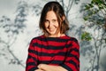 Portrait of a happy young woman looking up with perky look and arms crossed Royalty Free Stock Photo