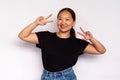 Portrait of happy young woman making peace gesture and smiling Royalty Free Stock Photo