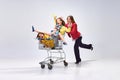 Portrait of happy young woman, mother going shopping with her little kids, children sitting in shopping trolley against Royalty Free Stock Photo