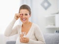 Portrait of happy young woman with pill and glass of water Royalty Free Stock Photo