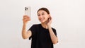 Portrait of happy young woman primping herself looking at mirror