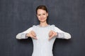 Portrait of happy young woman showing thumbs down in dislike gestures Royalty Free Stock Photo