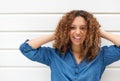 Portrait of a happy young woman smiling with hands in hair