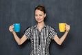 Portrait of happy young woman smiling and holding colored cups Royalty Free Stock Photo