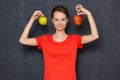 Portrait of happy young woman smiling and holding two apples in hands Royalty Free Stock Photo