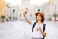 Portrait happy young woman taking selfie photo and looking at camera while in the city center on the square. Woman Royalty Free Stock Photo