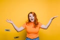 Portrait of a happy young woman, throwing banknotes, one after another, bright yellow background. Royalty Free Stock Photo