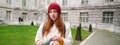 Portrait of happy young woman, tourist with backpack sightseeing, drinking hot tea from thermos, holding flask and Royalty Free Stock Photo