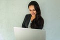 Portrait of a happy young woman using a laptop at home. Royalty Free Stock Photo