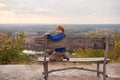 Portrait of happy young boy sitting on a wooden bench outdoors Royalty Free Stock Photo