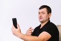 A portrait of a hard-of-hearing man who, with the help of gestures, speaks on video communication and shows a sign that