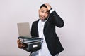 Portrait hard-working attaractive businessman with office box, folders, laptop talking on phone on white background Royalty Free Stock Photo